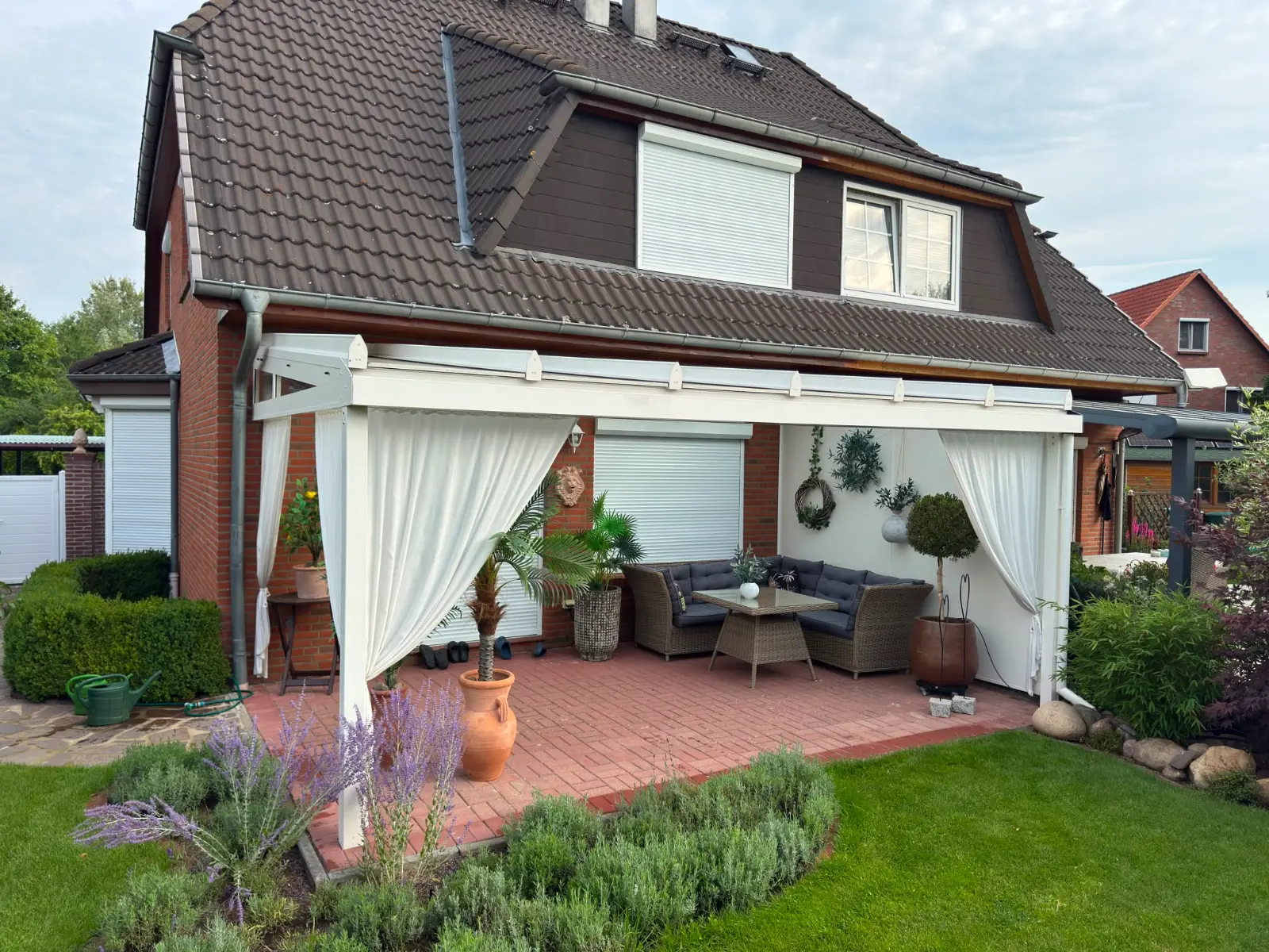 Moderne Glas-Terrassenüberdachung in gepflegtem Garten